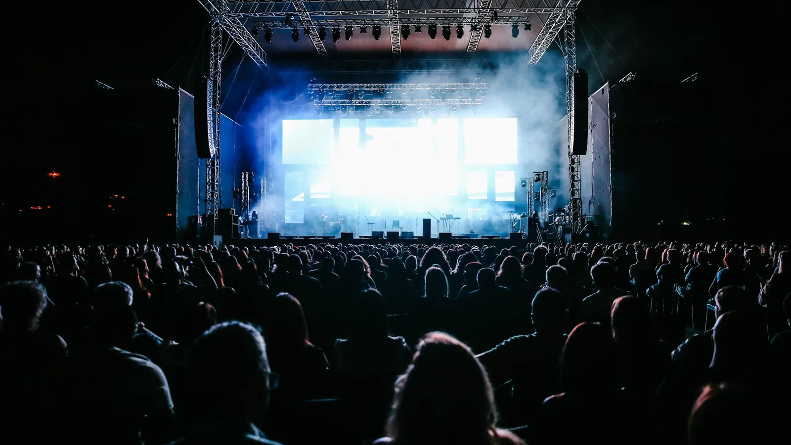 Concert crowd facing a lit stage